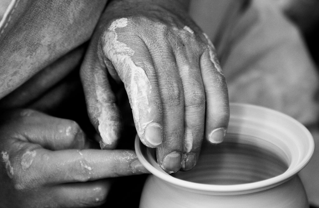 God's faithfulness in the hands of a potter molding a clay pot.